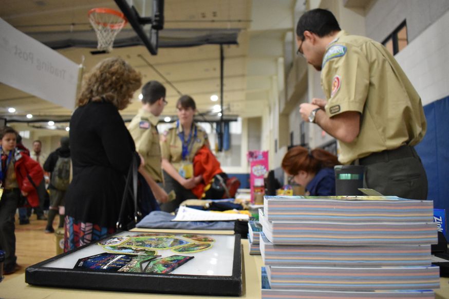 Boy scouts line up at an information table. 