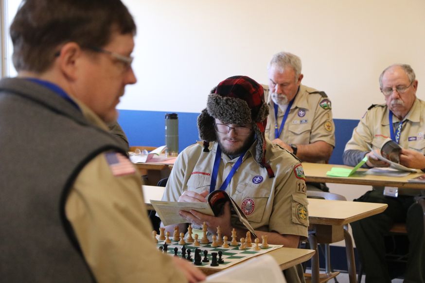 Boy scouts learning how to play chess.